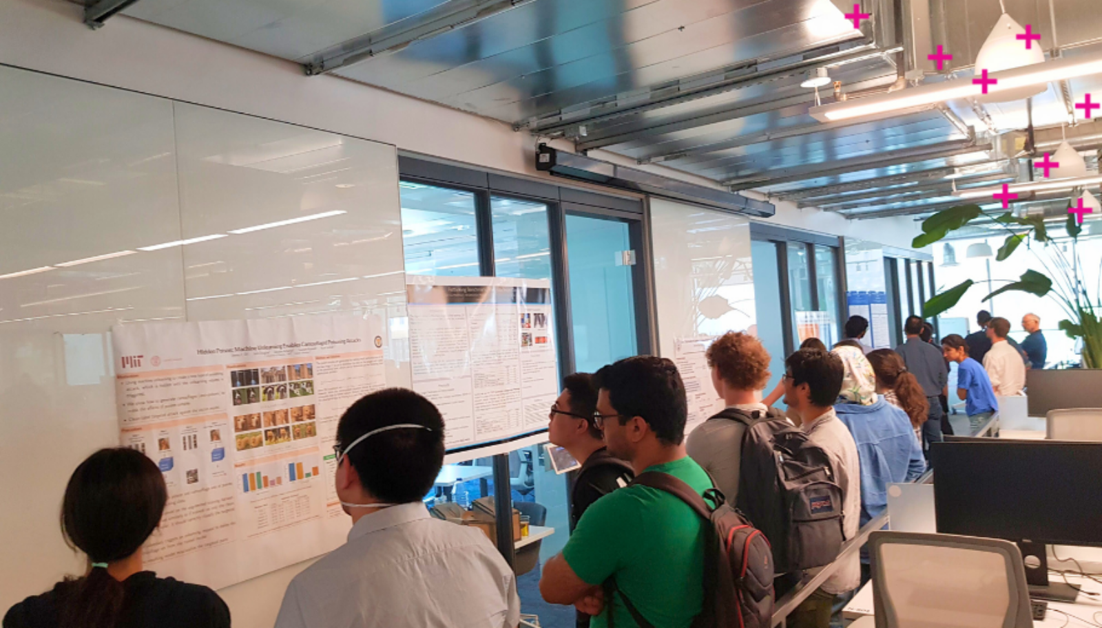 People look at research posters in the Vector hallway